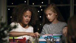 two girls doing crafts and it is night time